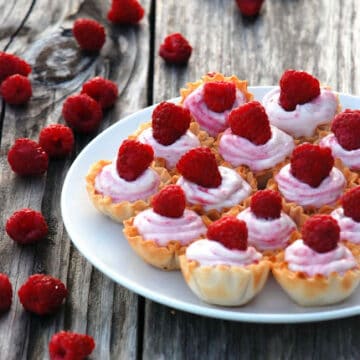 White plate filled with mini White Chocolate Raspberry Mousse in fillow cups.