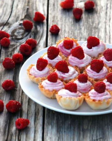White plate filled with mini White Chocolate Raspberry Mousse in fillow cups.