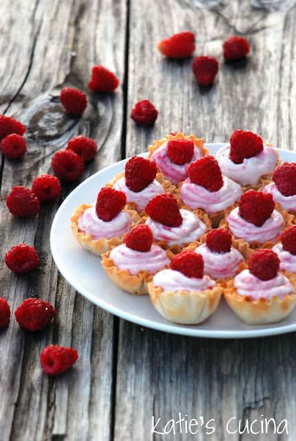 White plate filled with mini White Chocolate Raspberry Mousse in fillow cups.