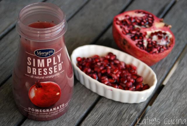 Marzetti Simply Dressed Pomegranate Dressing with pomegranate seeds on the side.