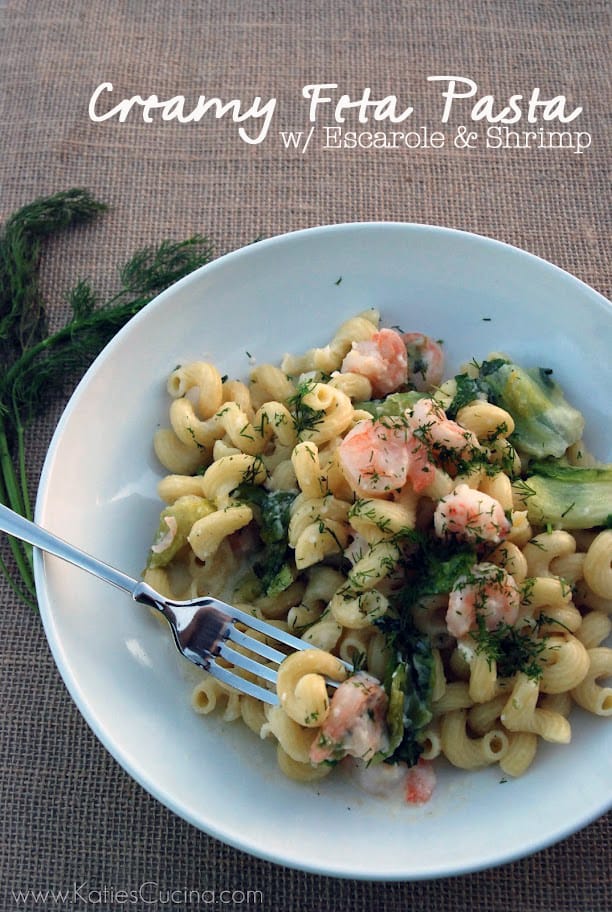 Top view of a white bowl filled with cork screw pasta, greens, and shrimp with text on image for pinterest.