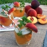 Three glasses of Peach Mojitos on a burlap table cloth.