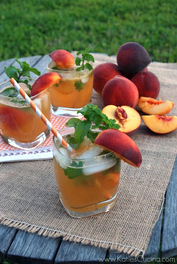 Three glasses of Peach Mojitos on a burlap table cloth.