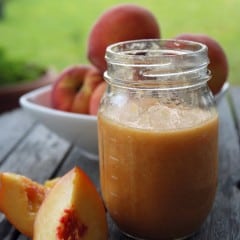 Mason jar of pureed peaches and peaches next to jar.