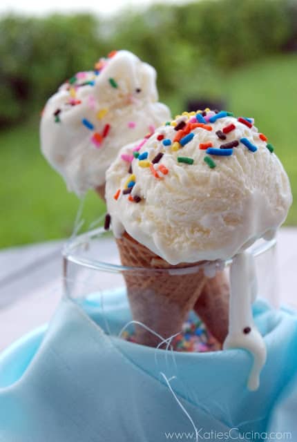Two cones of ice cream in a glass topped with sprinkles.