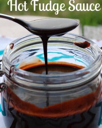 Spoon with chocolate sauce drizzling over jar.