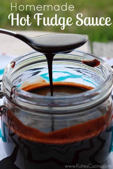 Spoon with chocolate sauce drizzling over jar.