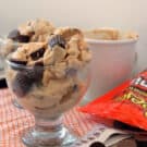 Glass bowl filled with peanut butter cups throughout and on the side of the glass.