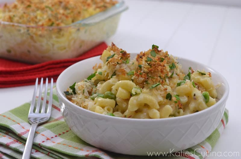 Bowl of cheese macaroni noodles topped with panko breadcrumbs and green herbs.