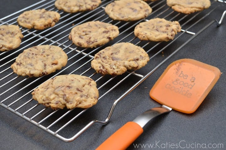 Cookies on a wire cooling rack with a orange spatula next to it.