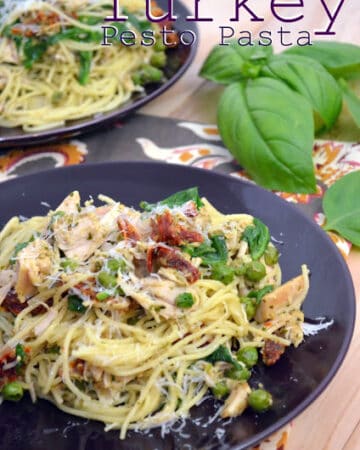 Two purple plates filled with pasta, turkey, spinach, and peas.