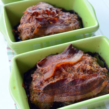 3 small bread pans filled with meat loaves topped with crisp bacon.
