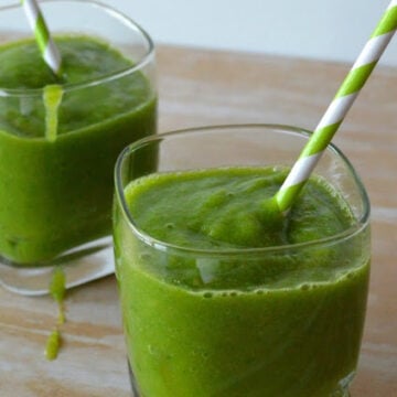 2 glasses of thick green liquid with paper straw sticking out.