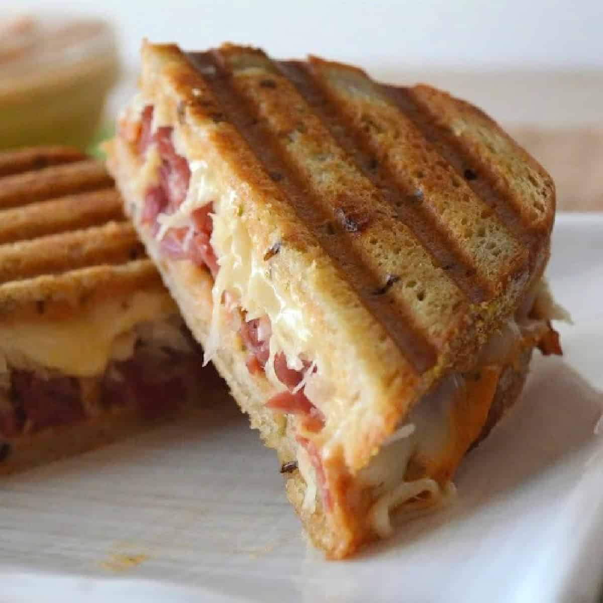 Two sandwiches with corned beef and sauerkraut on toasted bread.