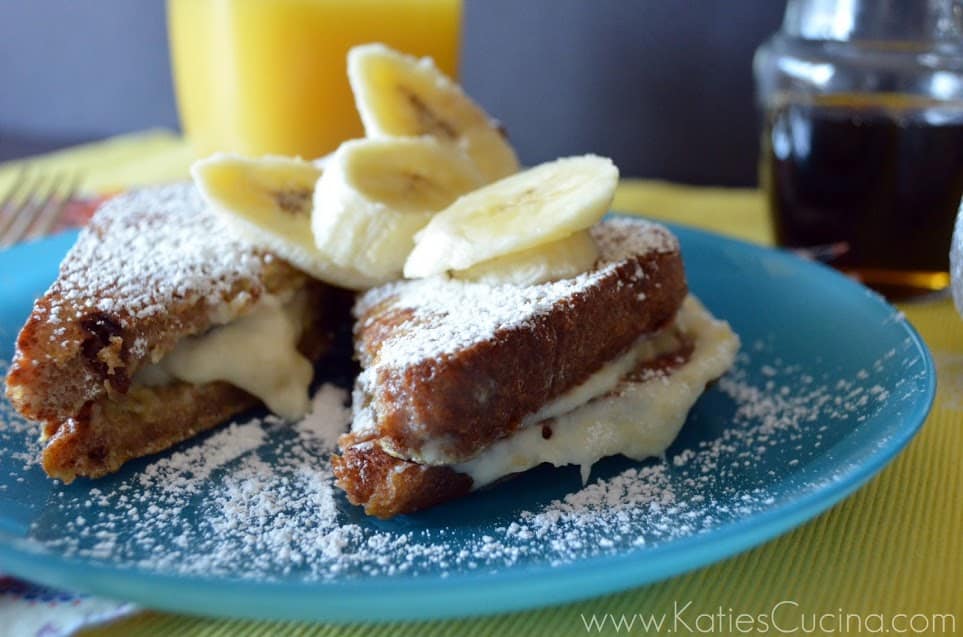 Plated French Toast topped with powdered sugar and banana slices.