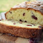Loaf of Cherry Almond Pound Cake with one sliced piece to show inside.