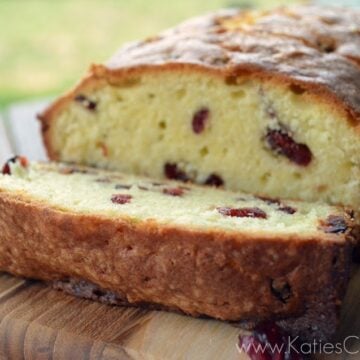 Loaf of Cherry Almond Pound Cake with one sliced piece to show inside.