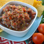 Bowl of Chunky Chipotle Cherry Tomato Salsa served with corn tortilla chips on the side.