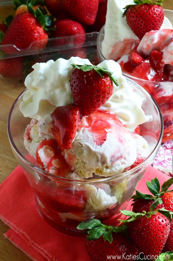 Close up of ice cream sundaes with strawberry sauce, shortcakes, fresh strawberries and whipped cream. 