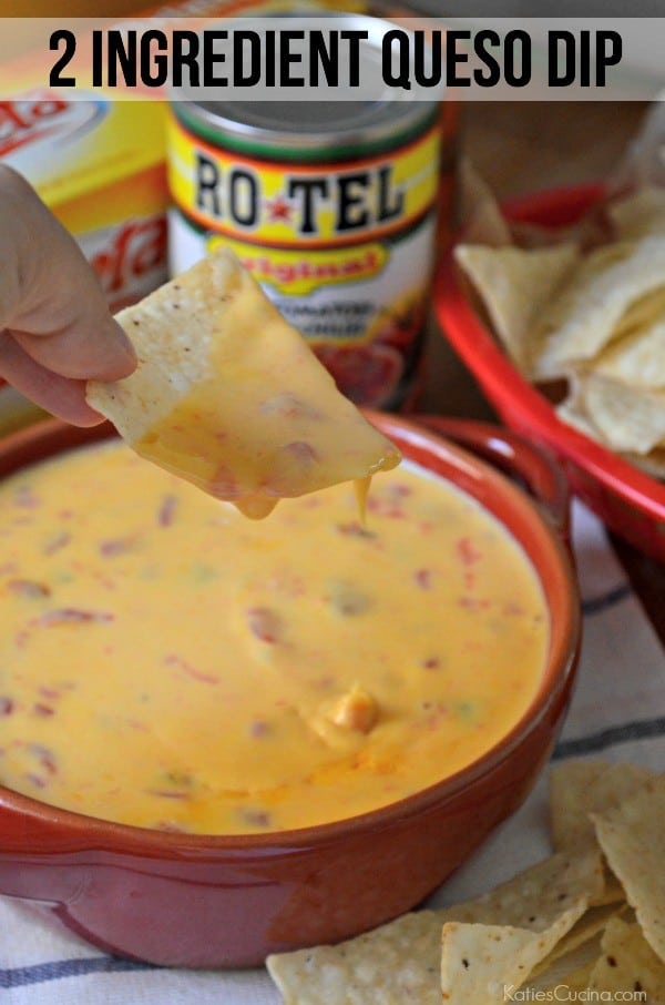 Female hand holding a chip covered in queso dip over a bowl with recipe title text on imaage for Pinterest.