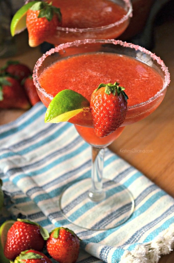 Frozen Strawberry Margarita on a counter with a blue striped cloth.