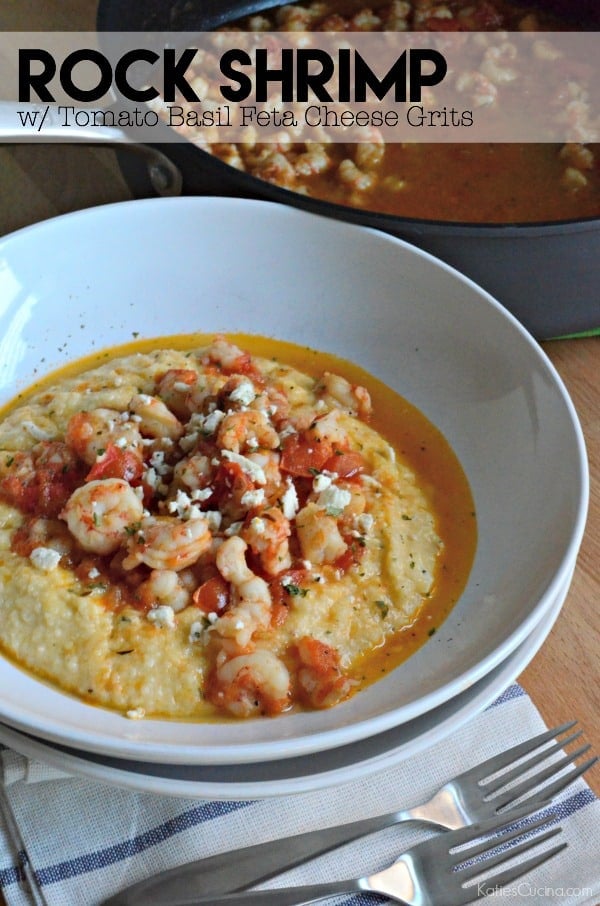 Two bowls stacked with shrimp and grits with sauce in the bowl. Large black skillet with shrimp and sauce in the background. 