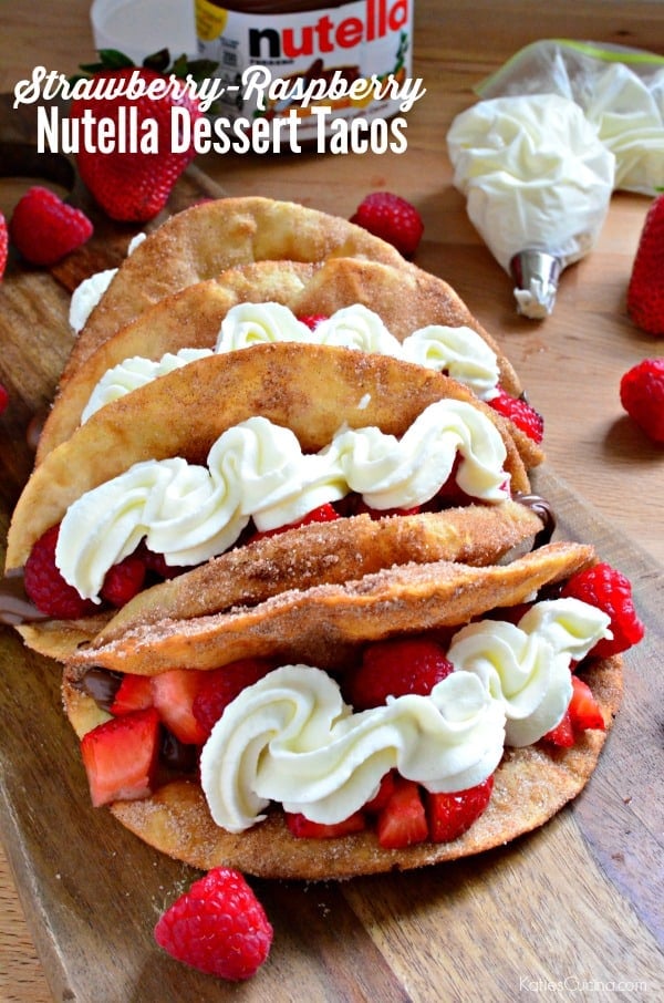 Dessert tacos filled with strawberries and whipped cream on a wood board with text on image for Pinterest.