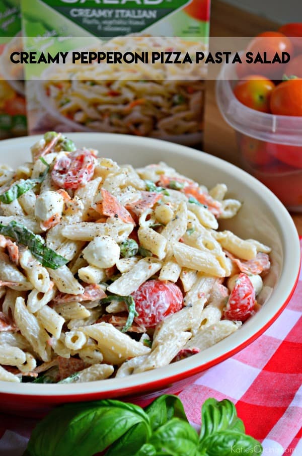 Close up of a creamy tubed pasta salad with tomatoes, basil, and pepperoni.