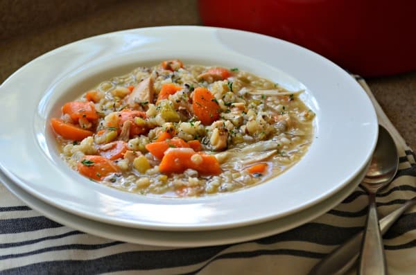 Two white bowls stacked with turkey soup in a bowl.