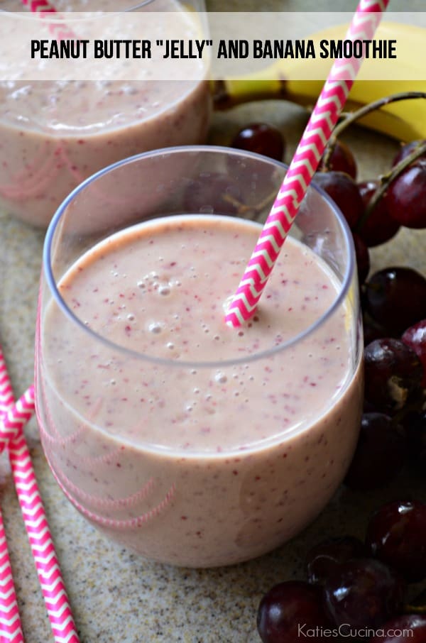 Stemless glass with pink smoothie, pinks straws and grapes.
