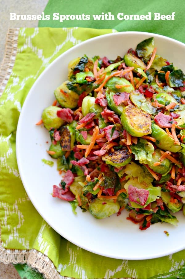 Top view of white bowl with brussels sprouts, carrots, and bacon.