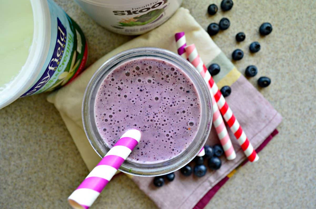 Top view of a purple smoothie with a purple and white striped straw.