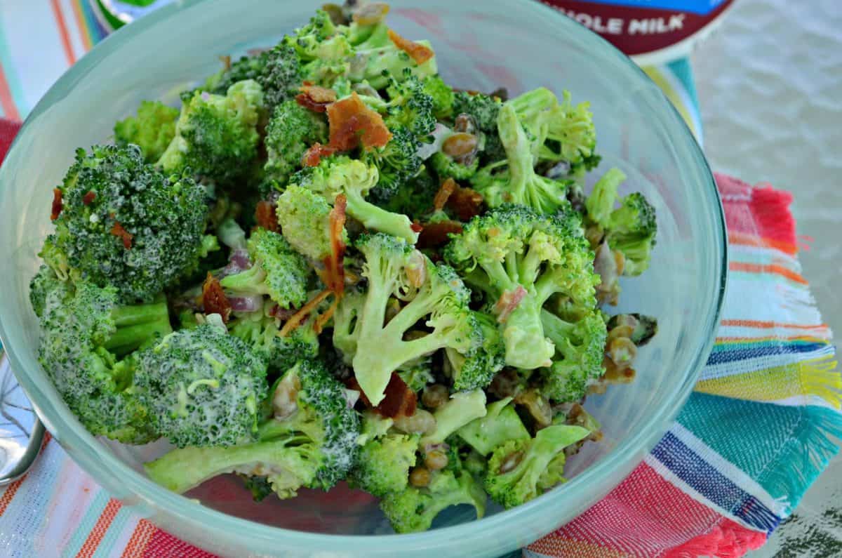 Blue bowl filled with broccoli and bacon.