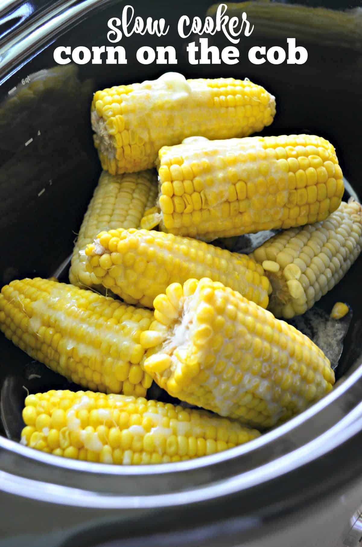 Ears of corn on the cob cut in half with butter on them in a slow cooker.