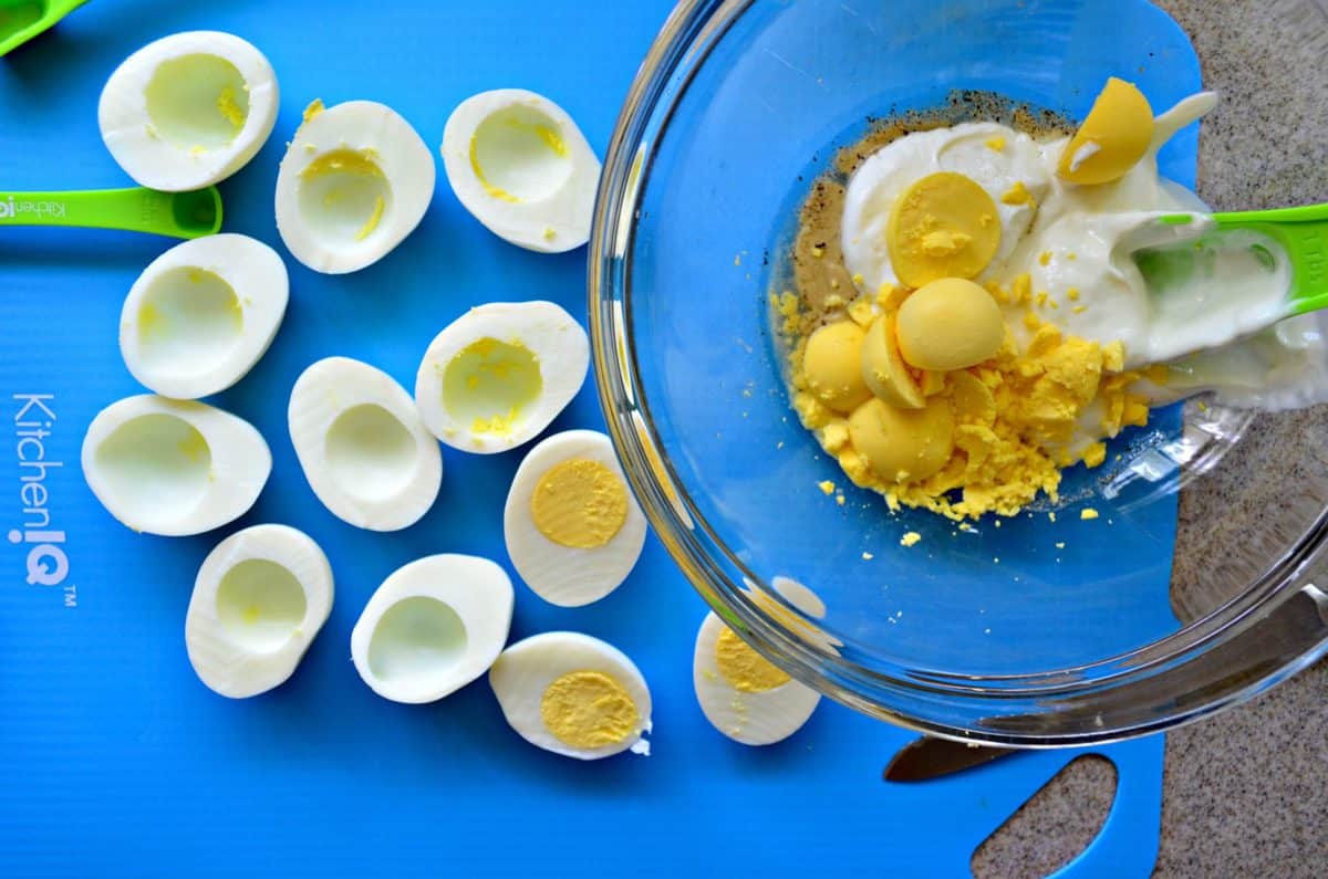 top view process photo of yolk removal into glass bowl for mashing up.