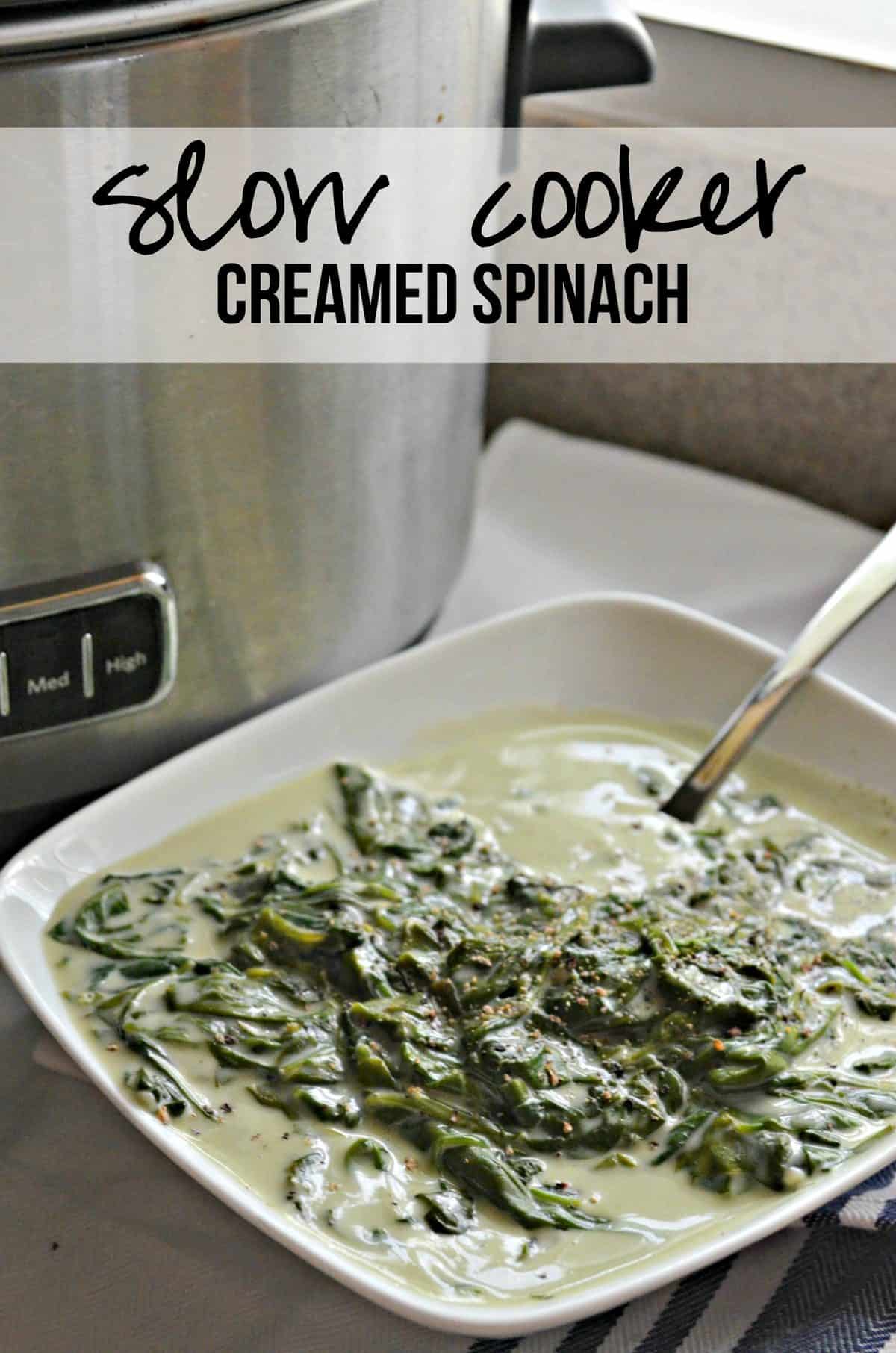 white bowl of Creamed Spinach with spoon in front of slow cooker with title text.
