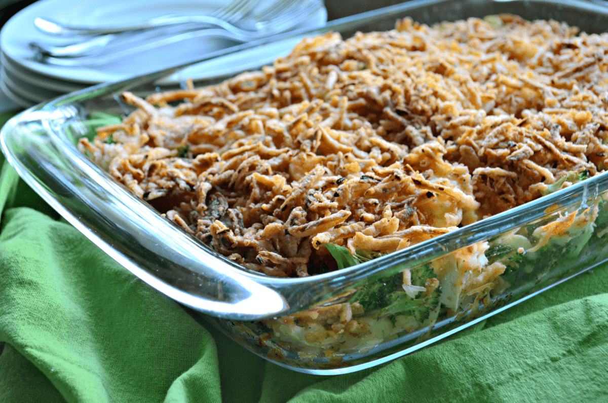 side view of Chicken Rice and Broccoli Casserole in casserole dish on green tablecloth topped with crisped onions.