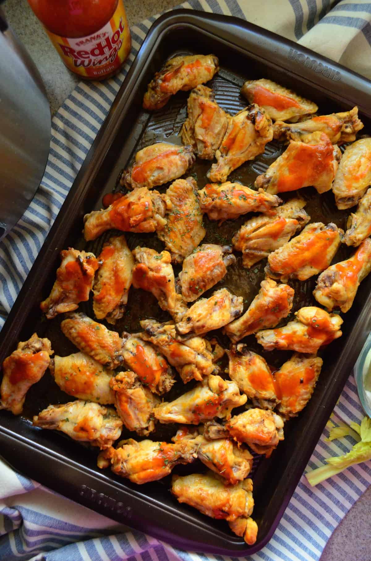 top view of wings smothered in buffalo sauce and spices on sheet pan.