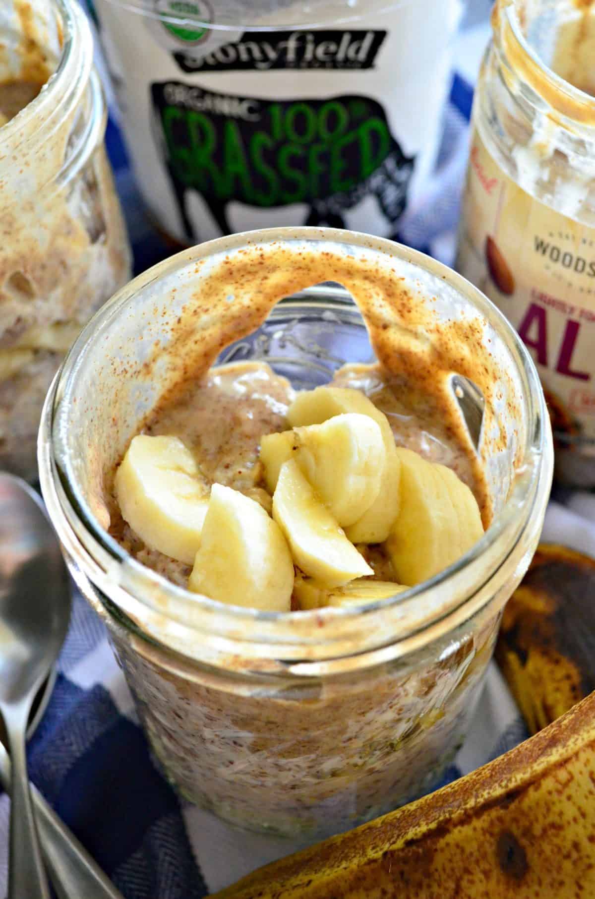 closeup top view of mason jar filled with almond butter, oats, and bananas.