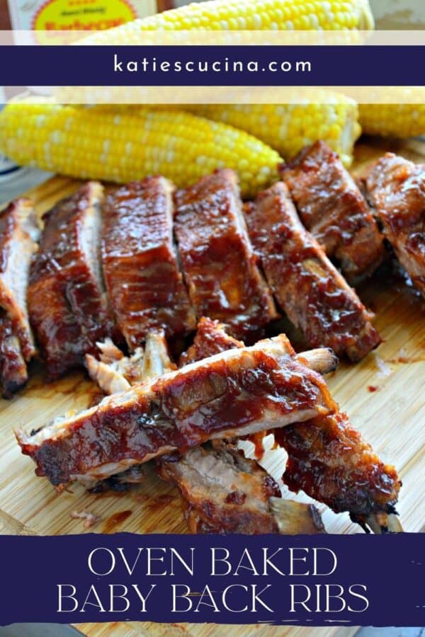 Close up of ribs sliced on a cutting board with corn in the background.