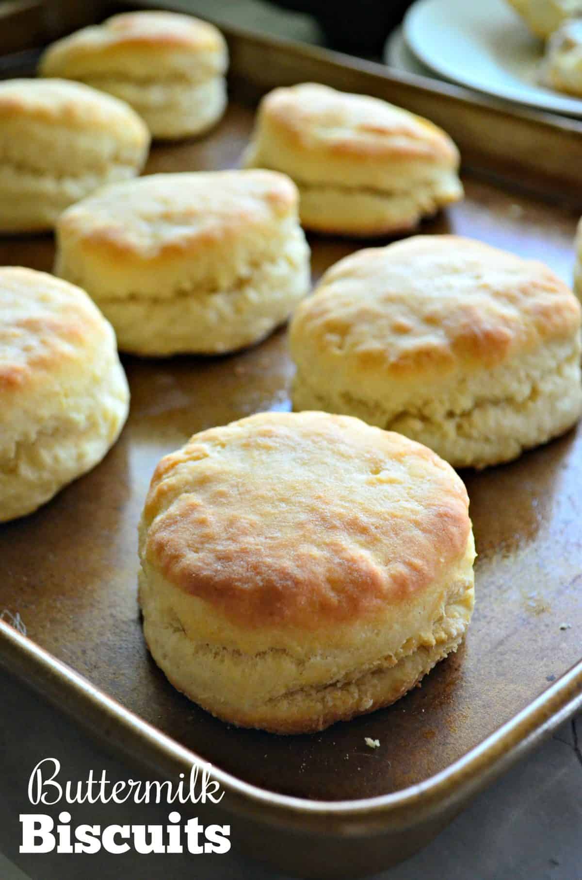 Close up of cooked biscuits on a brown baking tray with text on image.