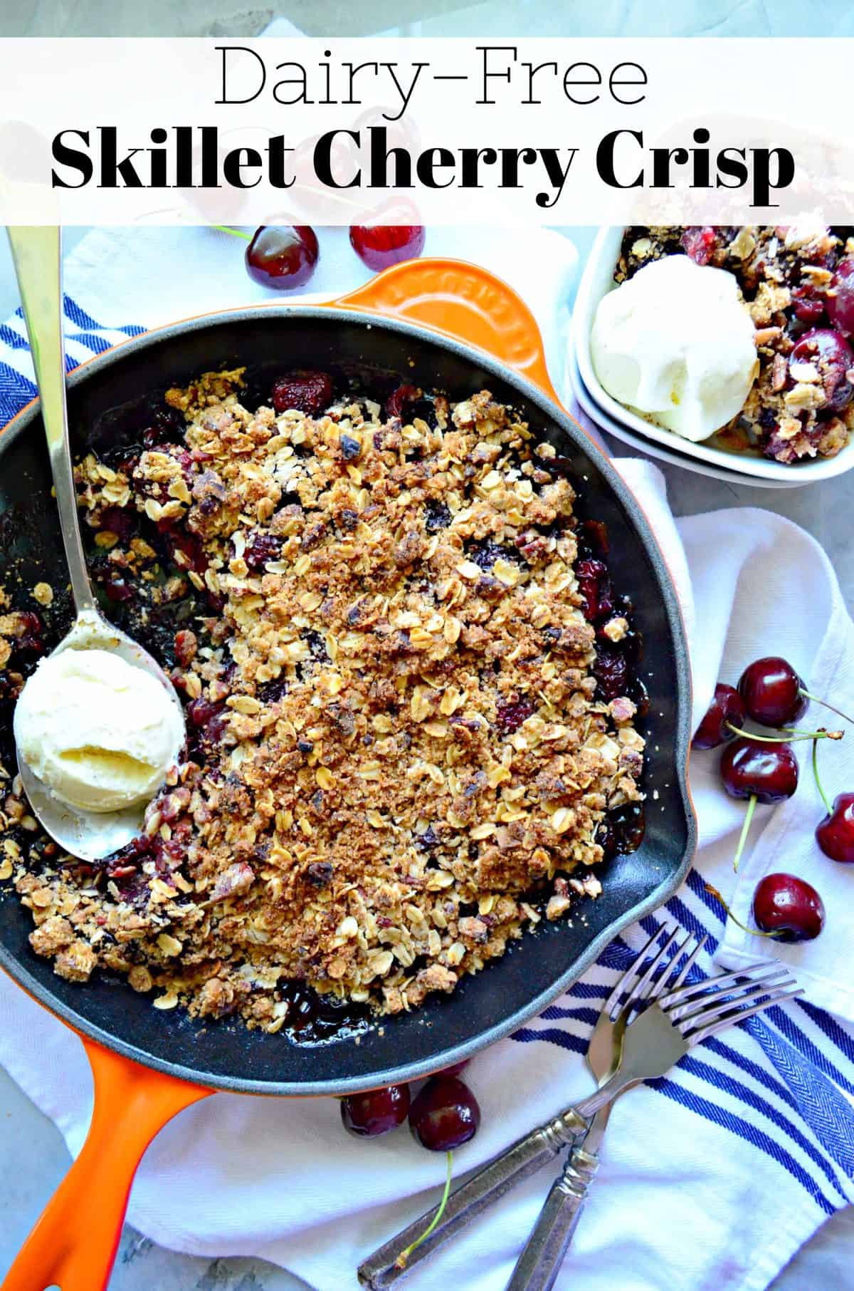 top view of cherry crisp topped with golden brown oatmeal with spoonful of ice cream in skillet with title text.