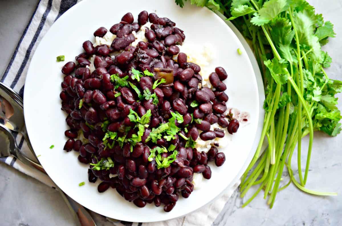 Top view of black bean sgarnished with cilantro on a white plate.