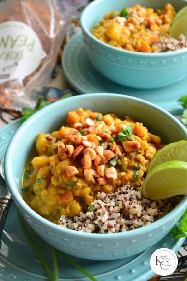 Close up of a teal bowl filled with lentil curry with qunioa and recipe title text on image for Pinterest.