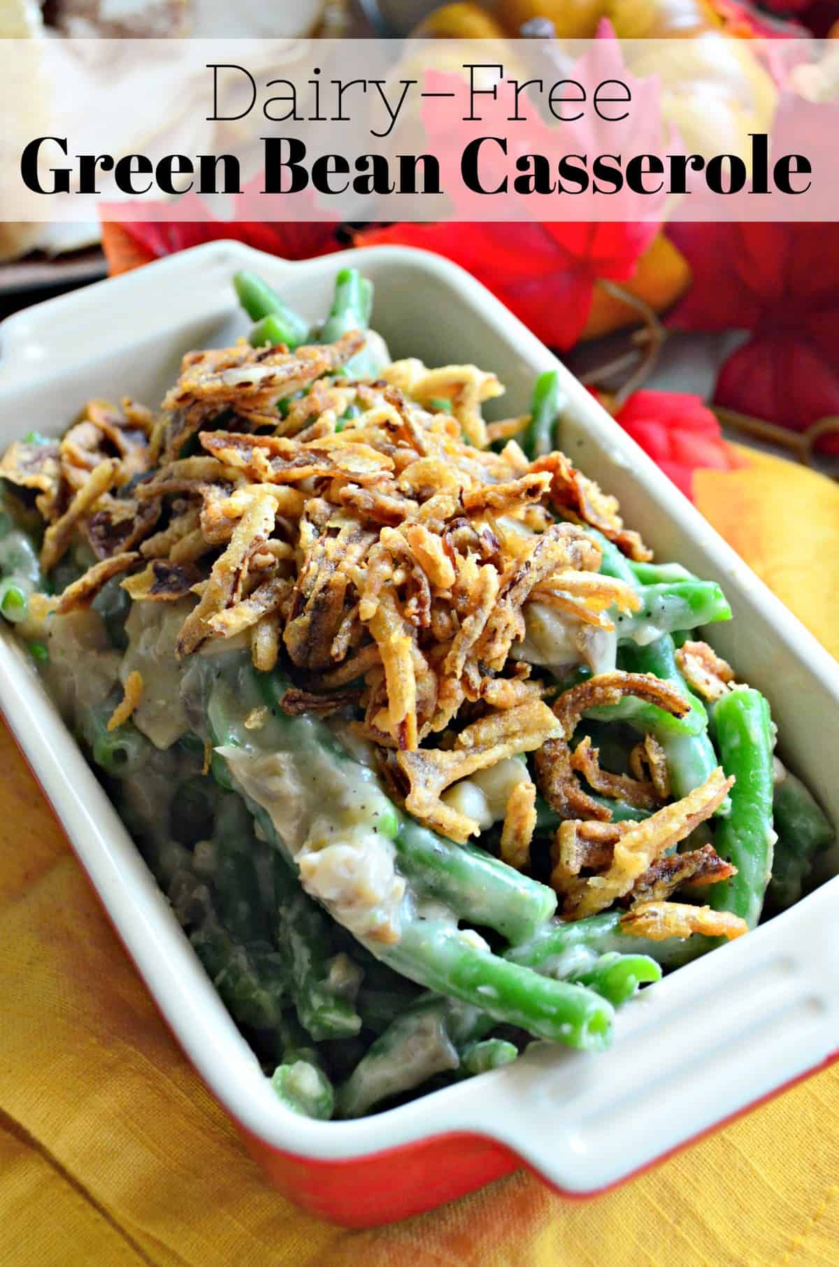 small casserole dish of green beans with white chunky substance topped with crispy onions. title text.
