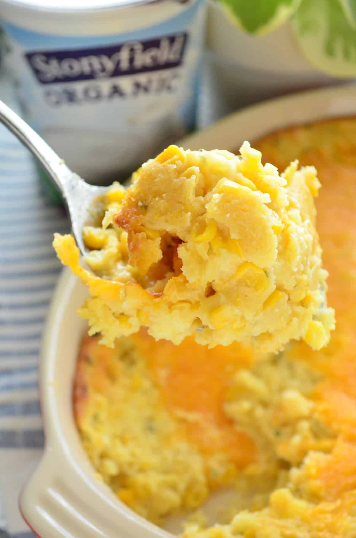 closeup of spoonful of Double Cream Corn Casserole with dish blurred in background.