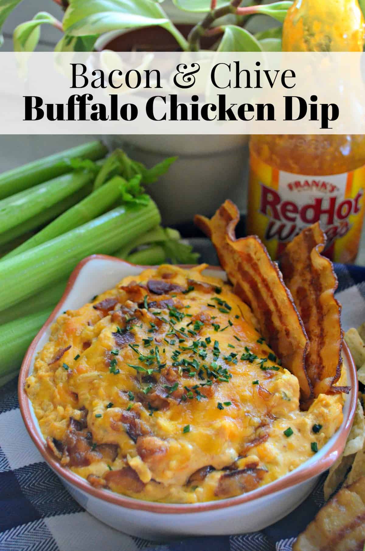 bowl of thick orange colored dip with bacon bits and herbs in front of Frank's Red Hot Wing sauce.