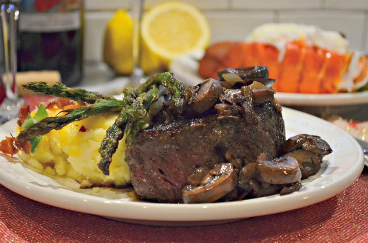 plated steak and potatoes with asparagus and mushrooms.