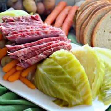 Instant Pot Corned Beef & Cabbage on a platter with rye bread on the side