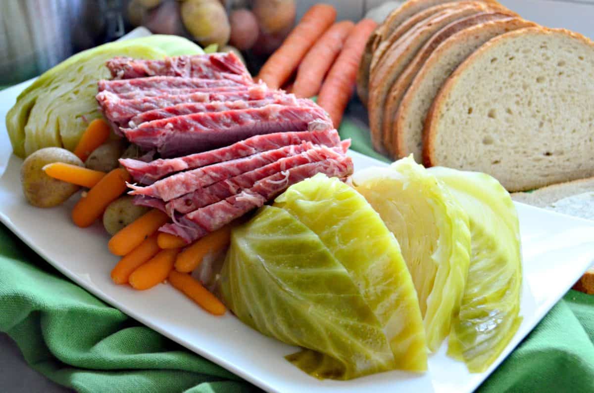 Instant Pot Corned Beef & Cabbage on a platter with rye bread on the side